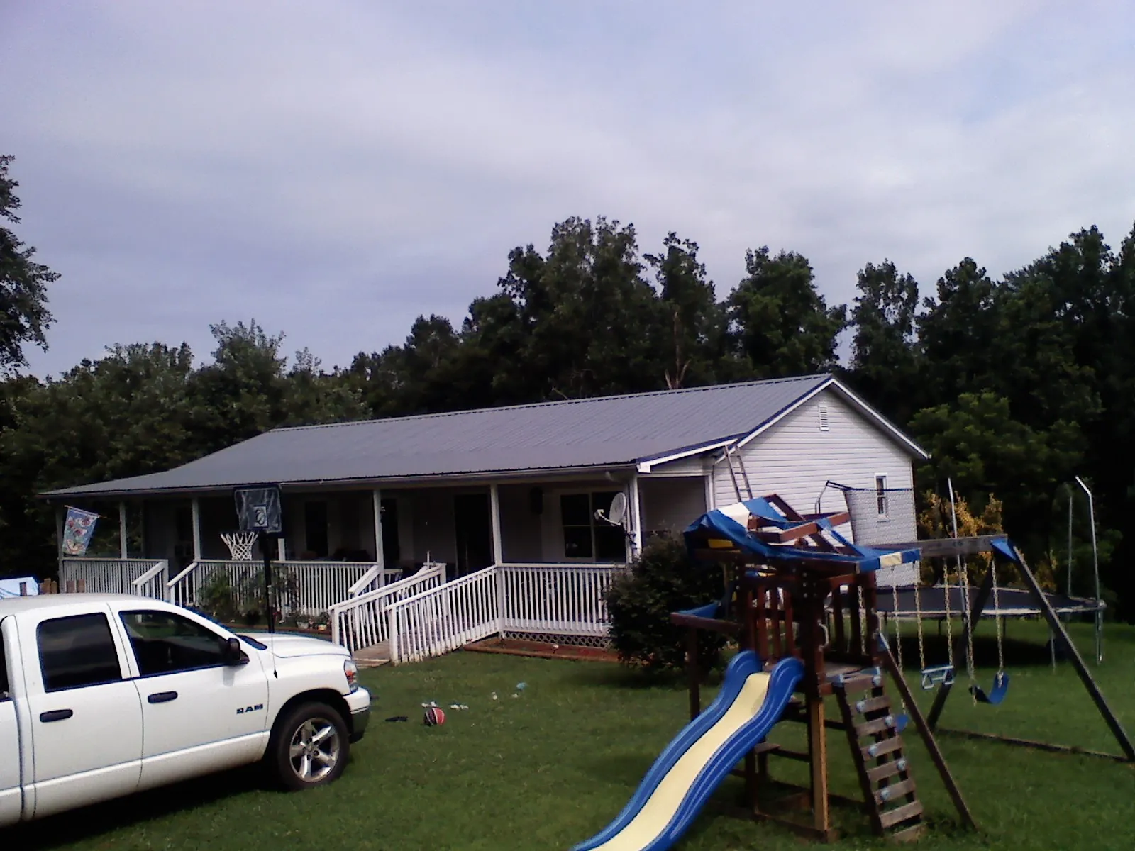 Dark metal roof on a country home with a full length front porch in Buffalo